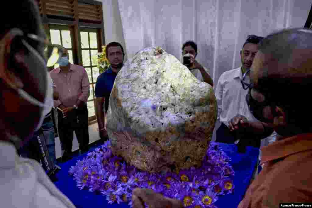 People inspect the single natural corundum (blue sapphire) named &#39;Queen of Asia&#39;, considered the largest found in the world, in Horana, some 45 km from Colombo, Sri Lanka.