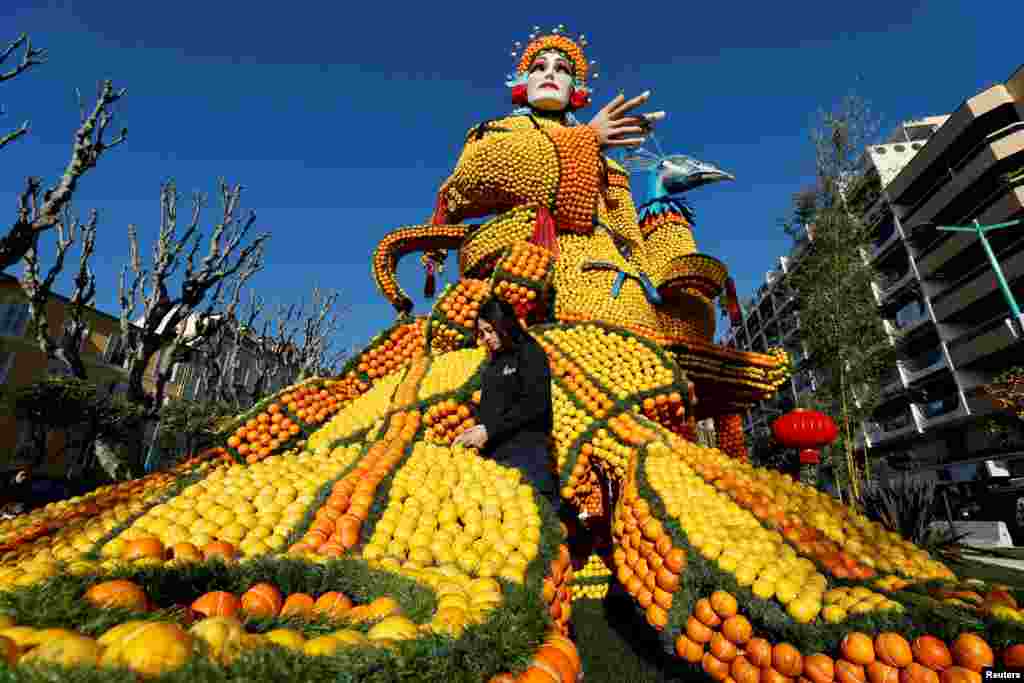A worker puts the final touches on a sculpture made with lemons and oranges named &quot;The Beijing Opera&quot; during the 88th Lemon festival around the theme &quot;Operas and dances&quot; in Menton, France.