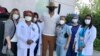 This image released by Damien Escobar shows Escobar with medical staff at Queens Hospital in the Queens borough of New York. Many people are reaching out to help others during the pandemic.