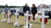 El presidente de Estados Unidos, Donald Trump, y la primera dama, Melania Trump, llegan para ver una fila de cruces de las víctimas del tornado en Beauregard, Alabama, EE. UU.