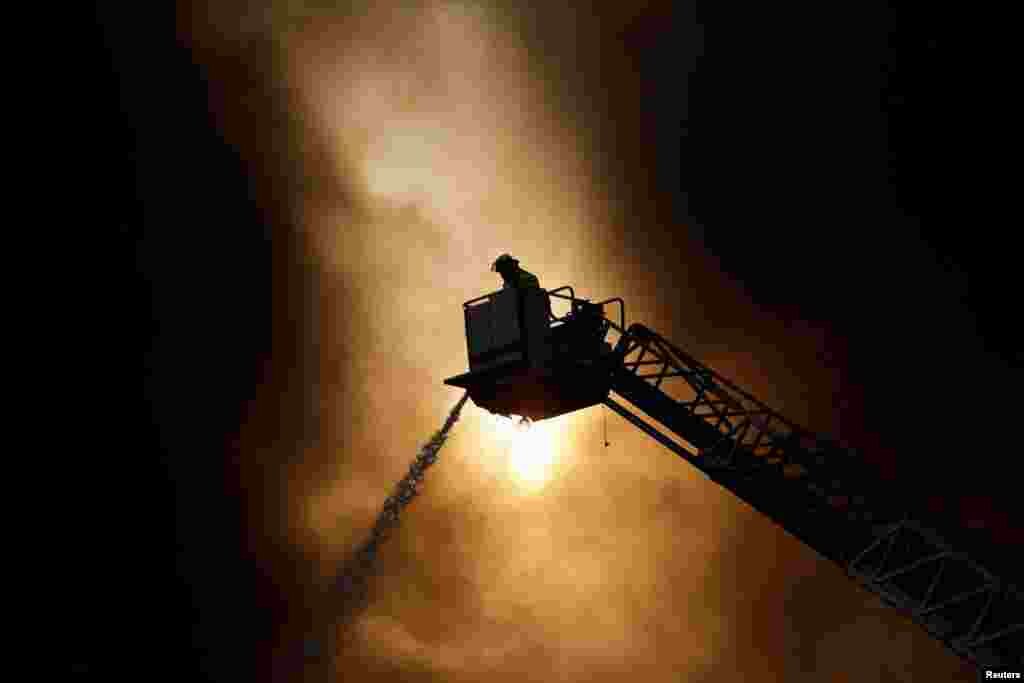 A firefighter extinguishes a fire at a factory at the industrial park &quot;FINSA II&quot; in Santa Catarina, on the outskirts of Monterrey, Mexico, Dec. 13, 2021.