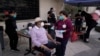 Wilbert Swaringer, a 71-year-old pastor who volunteers as a life coach for homeless people in downtown Los Angeles's Skid Row, talks to registered nurse Julie Hurtado before getting his COVID-19 vaccine in the courtyard of the Midnight Mission in…