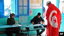 Un électeur tunisien drapé du drapeau national dans un bureau de vote à La Marsa, dans la banlieue de Tunis, le 21 décembre 2014.