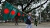 ঢাকায় বিজয় দিবসের আগে একজন বিক্রেতা বাংলাদেশের পতাকা নিয়ে। ১৪ ডিসেম্বর, ২০১৫। এপি ফাইল ছবি।