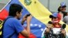 Un hombre toma una foto de una mujer mientras lleva una mordaza y una cadena, y sostiene micrófonos durante un mitin para conmemorar el Día Mundial de la Libertad de Prensa en Caracas, Venezuela. Foto de archivo
