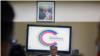 El embajador de Venezuela en Cuba, Alí Rodríguez Araque, hablando durante una conferencia de prensa bajo una fotografía del fallecido presidente de Venezuela Hugo Chávez.