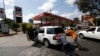 La gente empuja un automóvil sin gas a una de las pocas estaciones de combustible que tiene su propio generador eléctrico durante un apagón eléctrico en Caracas, Venezuela. Foto de archivo.