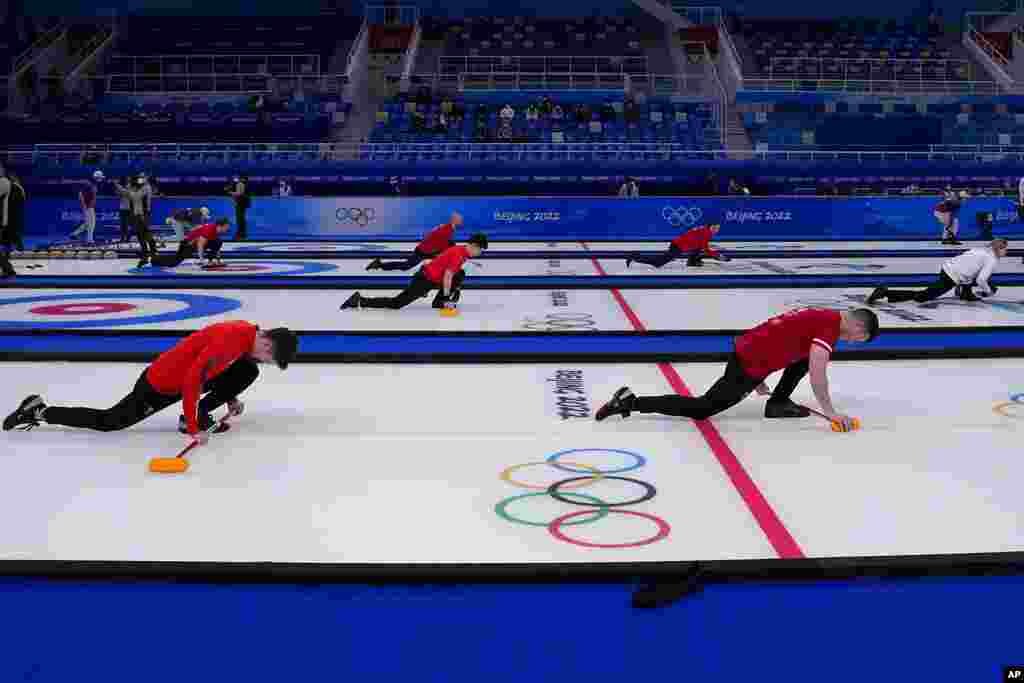 Men&#39;s teams warm up before their curling matches, at the 2022 Winter Olympics, in Beijing.