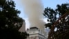 Smoke rises above the Houses of Parliament, behind the St. George's Cathedral, in Cape Town, South Africa, Jan. 2, 2022. 