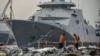Miembros de la Agencia Nacional de Búsqueda y Rescate inspeccionan los residuos recuperados de las aguas donde se cree que se estrelló el vuelo JT 610 de Lion Air, en el puerto de Tanjung Priok en Yakarta, Indonesia, el miércoles 31 de octubre de 2018.