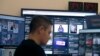 Un hombre trabaja en su escritorio frente a los monitores durante una presentación en una sala especial donde Facebook monitorea el contenido relacionado con las elecciones en la plataforma.