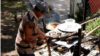 Un hombre cocina una pata de vaca en una casa ocupada por la comunidad Apacuana, en Caracas, Venezuela.