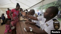 Refugees fleeing anti-immigrant violence are processed by immigration officers at a transit camp in Beit Bridge, ZImbabwe, April 24, 2015.