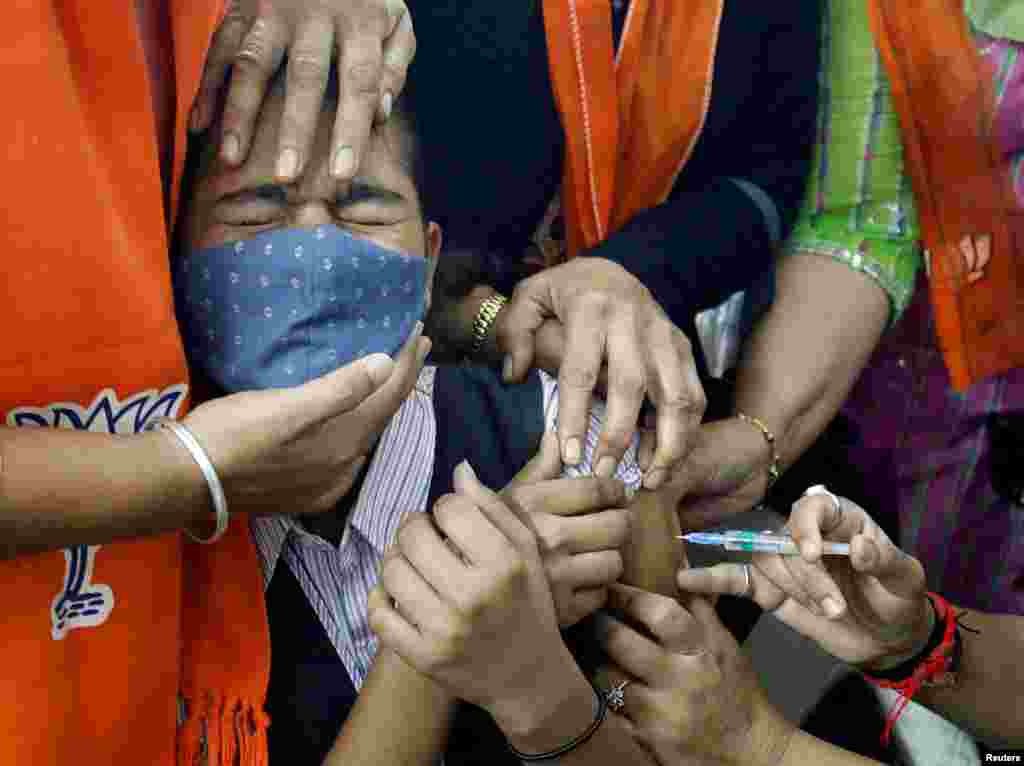 A girl reacts as she receives a dose of Bharat Biotech&#39;s COVID-19 vaccine, Covaxin, during a vaccination drive for children aged 15-18 years in Ahmedabad, India.