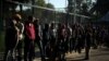 Migrantes de una caravana de miles que viajan desde Centroamérica hacia Estados Unidos, hacen fila para recibir donaciones de comida en un campamento levantado en Ciudad de México. Noviembre 6 de 2018. Reuters/Hannah McKay.
