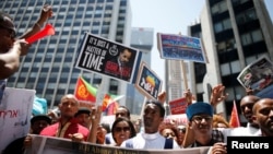 Plusieurs centaines de demandeurs d'asile érythréens en Israël ont manifesté en tenant des pancartes pour soutenir le nouveau rapport de l'ONU sur l'Erythrée sur les crimes comis par les belligerents du pays, Israël, le 21 juin 2016.
