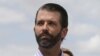 Donald Trump Jr escucha a su padre el presidente Donald Trump durante una visita a Lake Okechobee y la represa Herbert Hoover en Canal Point, Florida, el 29 de marzo de 2019.