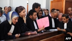 Les familles de victimes de la révolution tunisienne assistent à un procès au palais de justice de la ville de Kasserine, au centre de la Tunisie, le 13 juillet 2018.