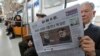 一名乘客在韩国首尔地铁中阅读朝鲜日报，该报头条报道计划中的美国总统川普与朝鲜领导人金正恩的首脑会谈。（2018年3月10日）